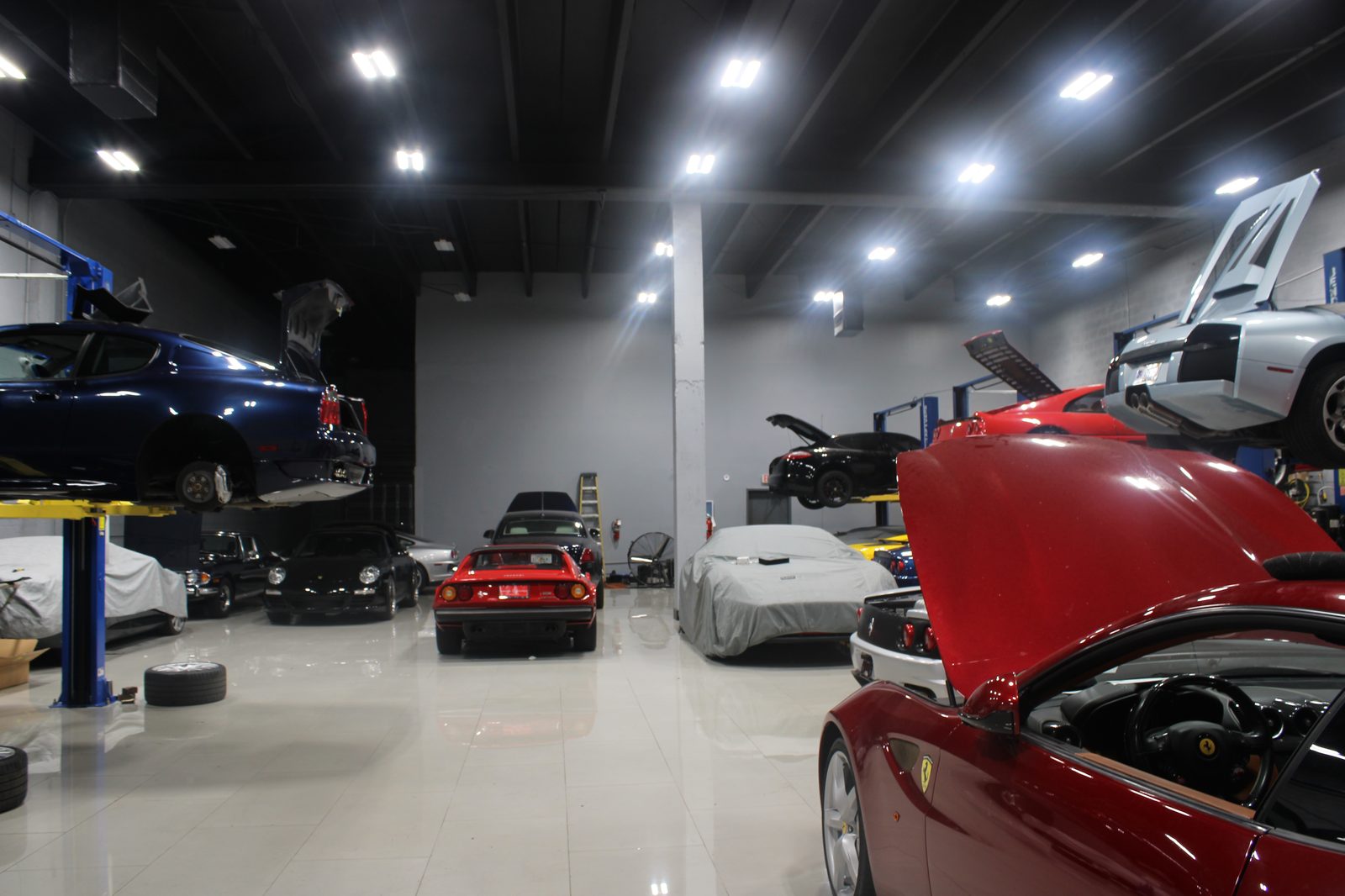 Workshop wide view — multiple Ferraris under work lights