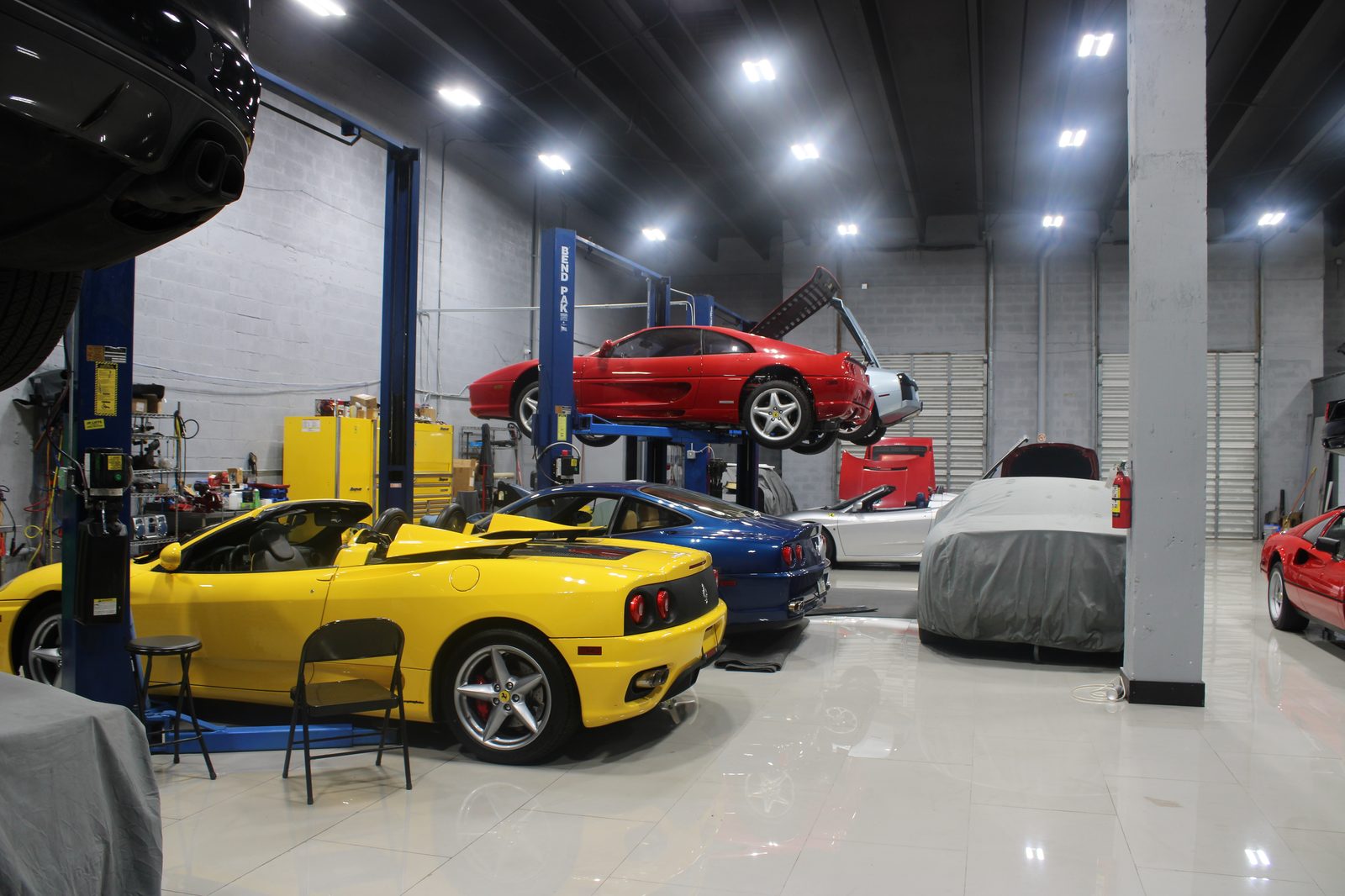 Lamborghini Murciélago, Ferrari 360, and red Ferrari F355 on lifts